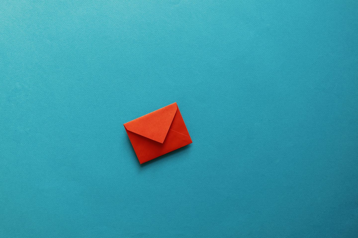 Application for your studies at the HWR Berlin: a small red envelope lies on a turquoise surface. Photo: © tolgart/iStock/Getty Images Plus