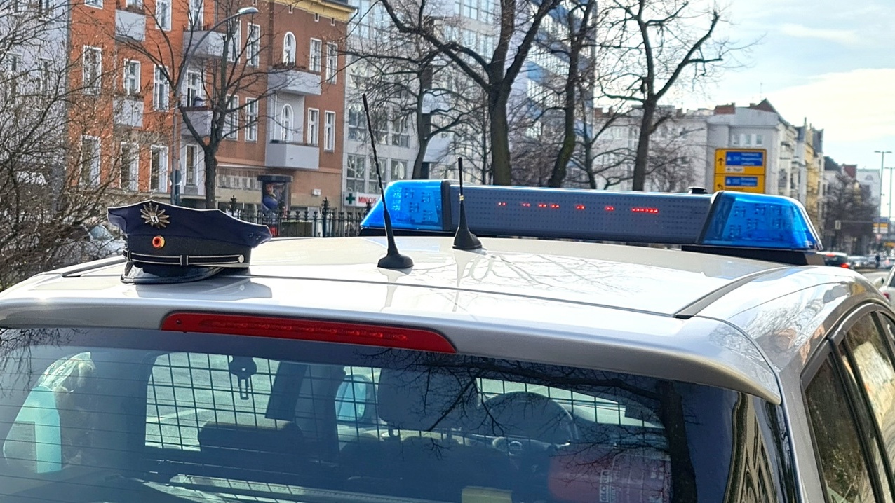 Dach von einem Polizeoauto. Darauf eine Polizistenmütze.