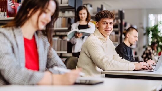 Dual studieren an der HWR Berlin: Vier Studierende arbeiten in der Bibliothek am Laptop. Foto: Lukas Schramm