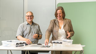 Ein Mann und eine Frau stehen an einem Design Thinking Tisch. Foto: Startup Incubator Berlin