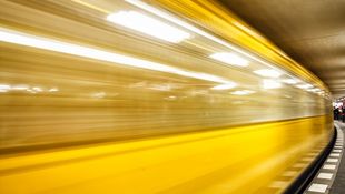 [Translate to English:] Bewegungsunschärfe: Eine orangegelbe U-Bahn der BVG fährt in einen Berliner Bahnhof ein. Foto: © PhotographerCW/Getty Images/iStockphoto