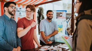 Vier Studierende an einem Marktstand bei den Internationalen Tagen der HWR Berlin im Oktober 2019