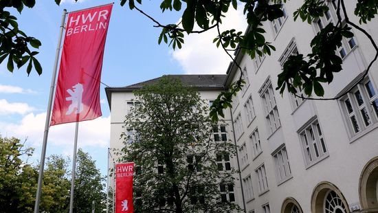 Das Foto zeigt die rote Fahne mit dem weißen Logo der HWR Berlin vor dem Haupteingang am Campus Schöneberg. Foto: Oana Popa-Costea