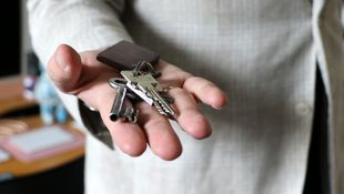 Eine Person hält einen Schlüsselbund in der flachen Hand.