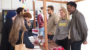 [Translate to English:] Studierende unterhalten sich an einem Stand