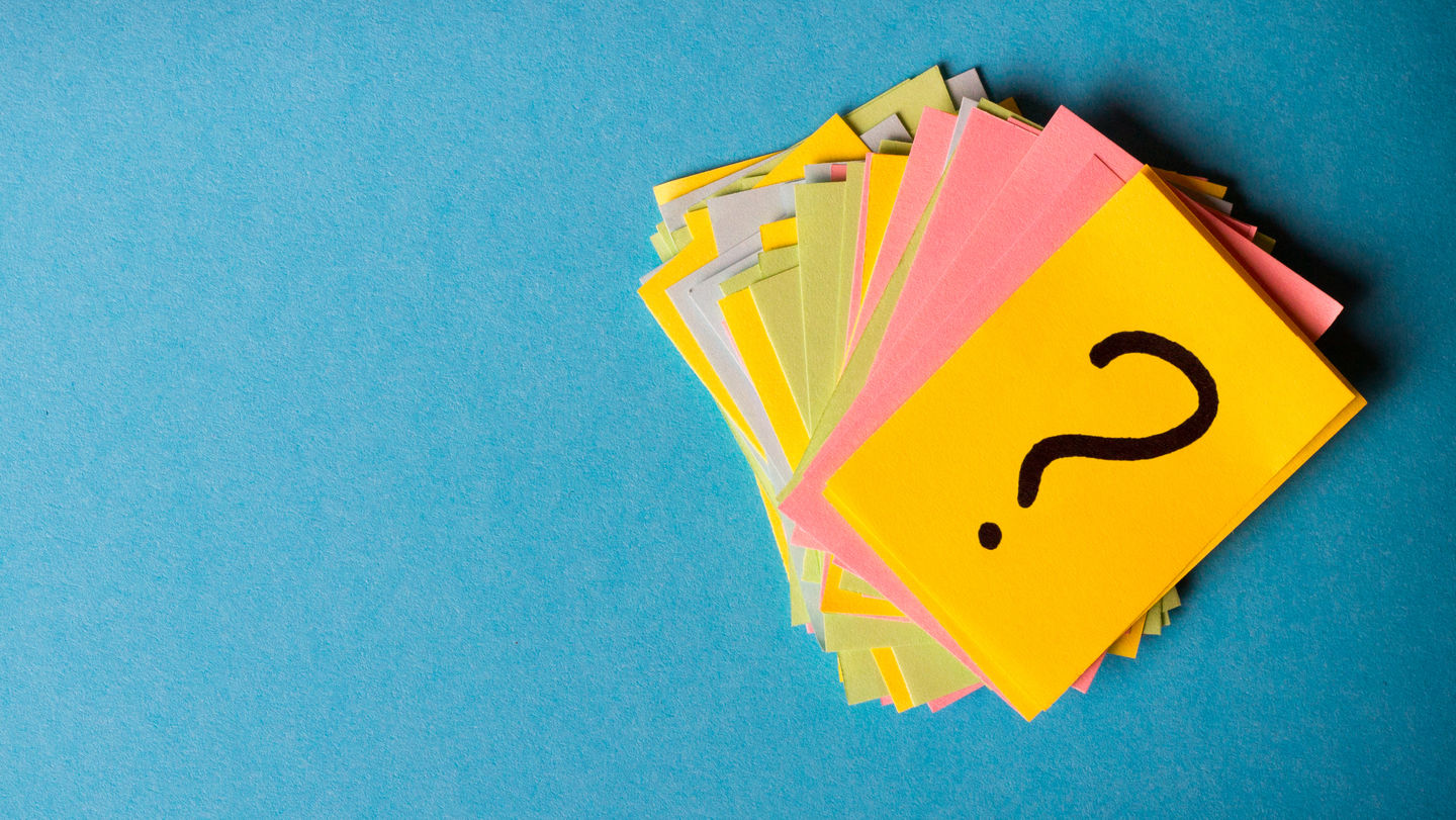 A stack of different coloured Post-it notes. The top Post-it has a black question mark on it. Photo: © Mykola Sosiukin/Getty Images/iStockphoto
