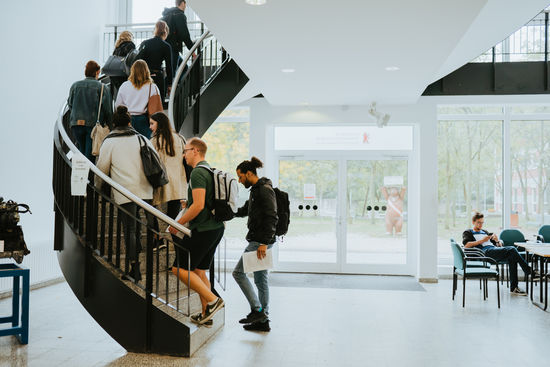 Campus Lichtenberg of the HWR Berlin: Students walk up a spiral staircase. Photo. Oana Popa-Costea