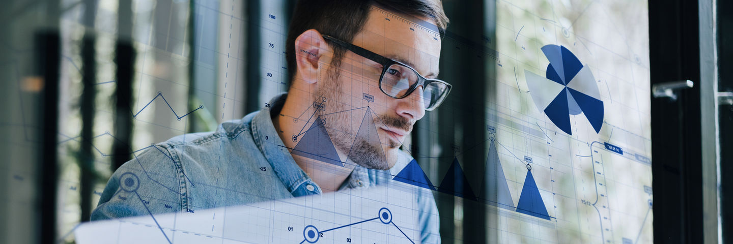 Porträt eines jungen Mannes mit Jeanshemd und Brille wird überlagert von Diagrammen.