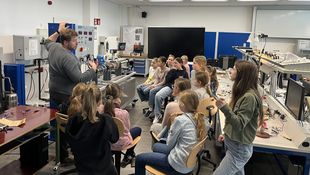 Mädchen in einem Technik-Labor, Dozent erklärt etwas