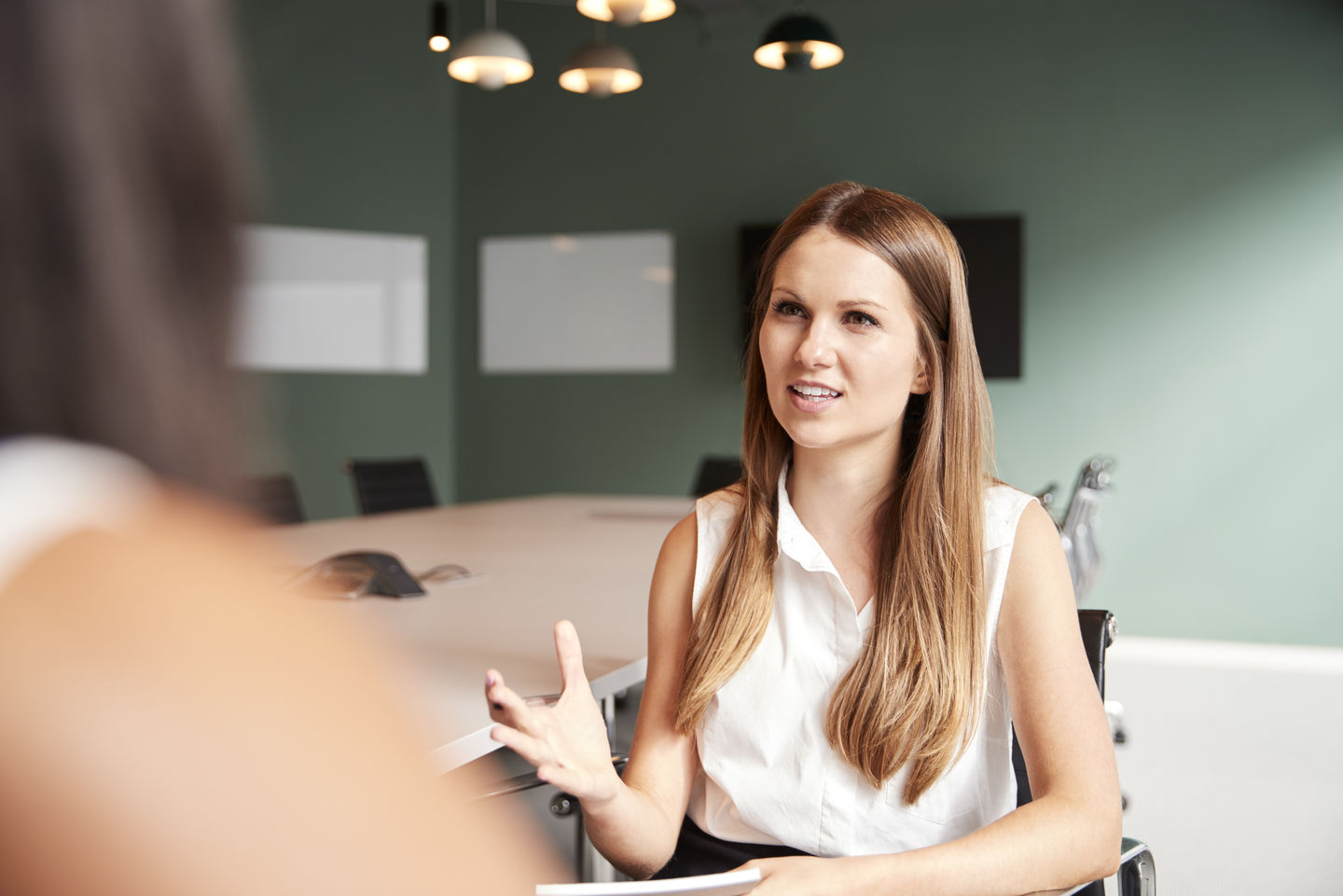 Bewerbung duales Studium an der HWR Berlin: Dual Studierende diskutiert am Konferenztisch ihres Unternehmens mit einer Kollegin. Foto: © monkeybusinessimages/ Getty Images/ iStockphoto