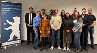 Gruppenfoto, links eine Infotafel des Rechnungshofes