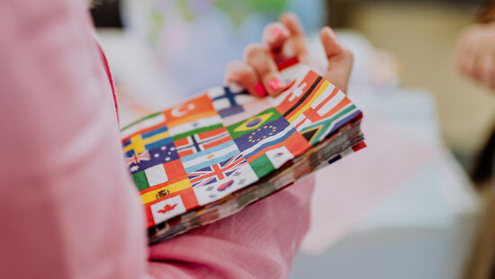 International Office der HWR Berlin: Eine Studierende hält einen Stapel Servietten mit Länderflaggen in der Hand. Foto: Lukas Schramm