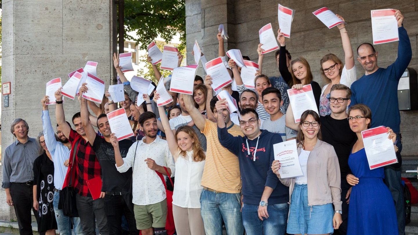 Absolventen der Summer School auf Treppe mit Zertifikat.