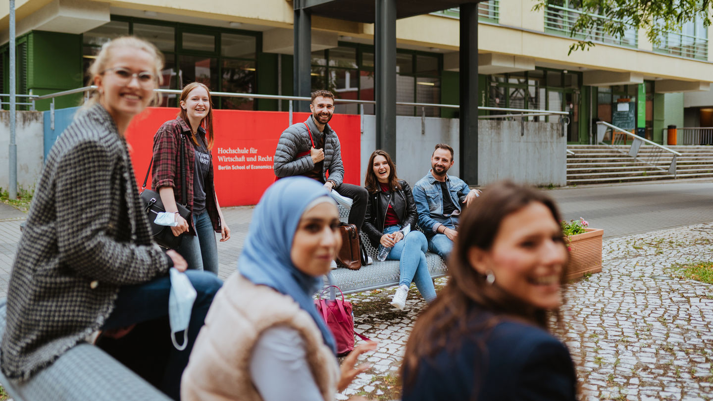 Sommersemester 2022: Studierende der HWR Berlin sitzen im Hof vor dem Eingang der Hochschule am Campus Lichtenberg. Foto: Oana Popa-Costea