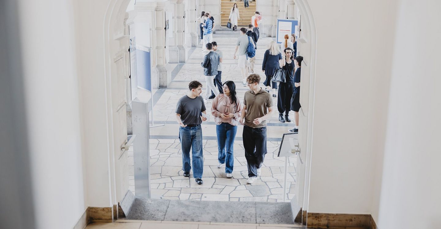 Drei Studierende am Campus Schöneberg der HWR Berlin, die sich unterhalten. 