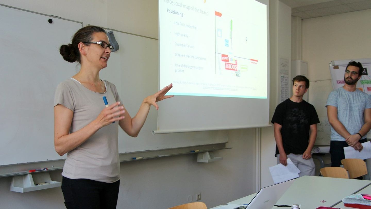 Am 20. April 2021 laden drei Berliner Hochschulen für angewandte Wissenschaften ein zu einer Online-Veranstaltung mit Informationen und Berichten über die Berufsperspektive Hochschulprofessorin. Foto: Sylke Schumann Lehrende steht an einem Whiteboard, recht von ihr läuft eine Präsentation.