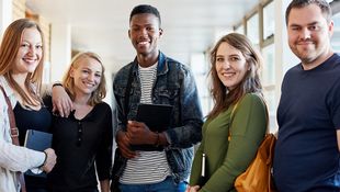 Bachelor application at the HWR Berlin: Three female and two male students smile into the camera. Foto: © LumiNola/E+/Getty Images