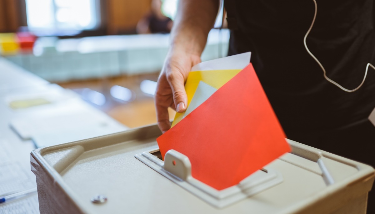 Roter Umschlag wird in eine Urne geworfen.