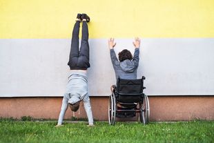 Illustration: Zwei Personen vor einer Wand, eine macht Handstand, die andere hebt im Rollstuhl die Hände nach oben