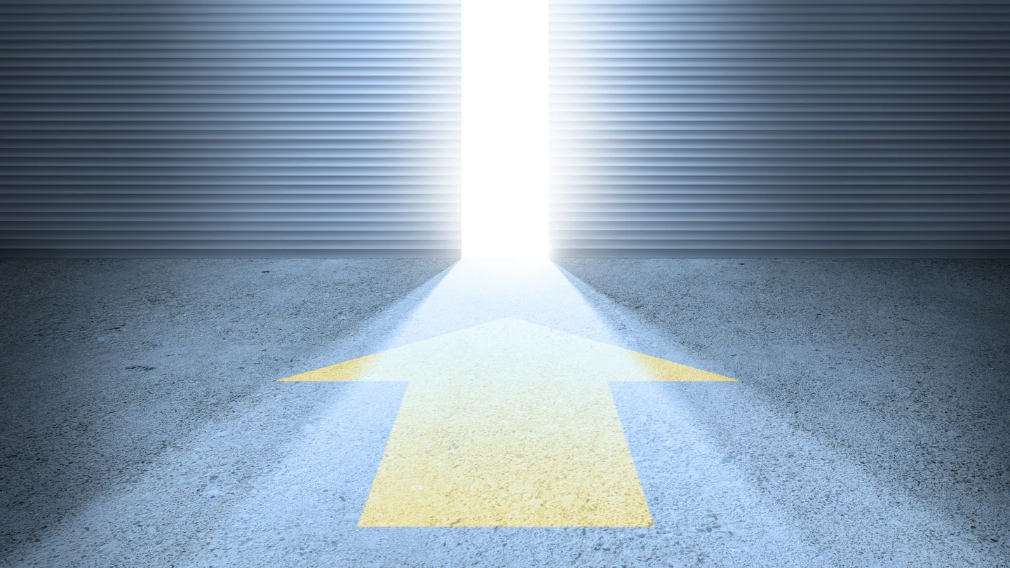 Studienbeginn an der HWR Berlin: Infos für Ersties zum Studienstart. Foto: © olaser/Getty Images/iStockphoto Ein gelber Pfeil auf dem Asphalt weist auf ein halb geöffnetes Tor, durch das helles Sonnenlicht hereinfällt. Foto: © olaser/Getty Images/iStockphoto