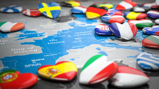Karte von Europa mit Herzmagneten in den Flaggenfarben verschiedener Länder wie Schweden, Dänemark, Frankreich, Spanien, Italien und Griechenland