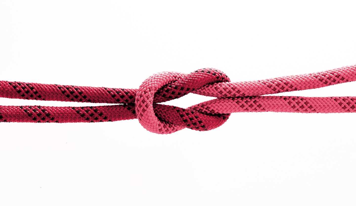 One red and one pink rope knotted together.