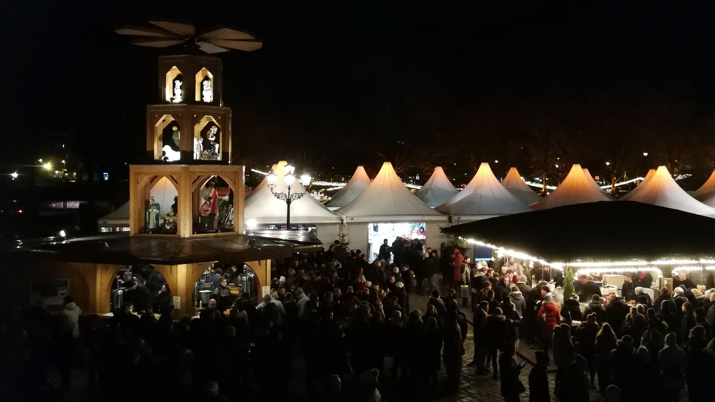 Nachtaufnahme: Weihnachtsmarkt auf dem Berliner Breitscheidplatz mit Ständen und Weihnachspyramide.