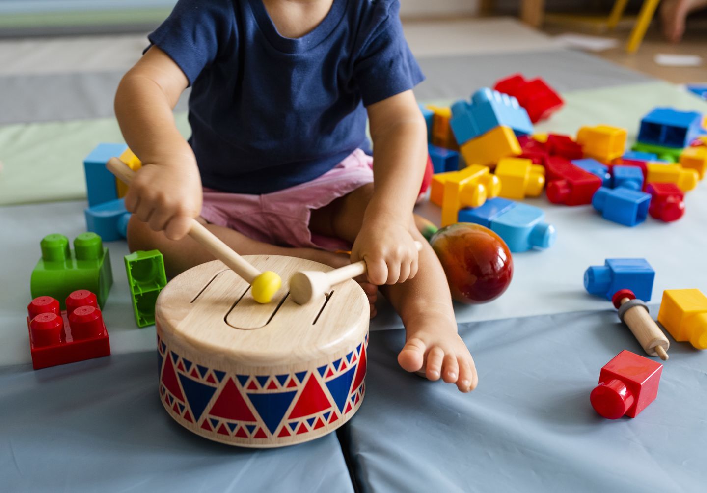 Kleinkind trommelt mit Schlegeln auf einer bunten Trommel. Foto: © Rawpixel Ltd./Getty Images/iStockphoto
