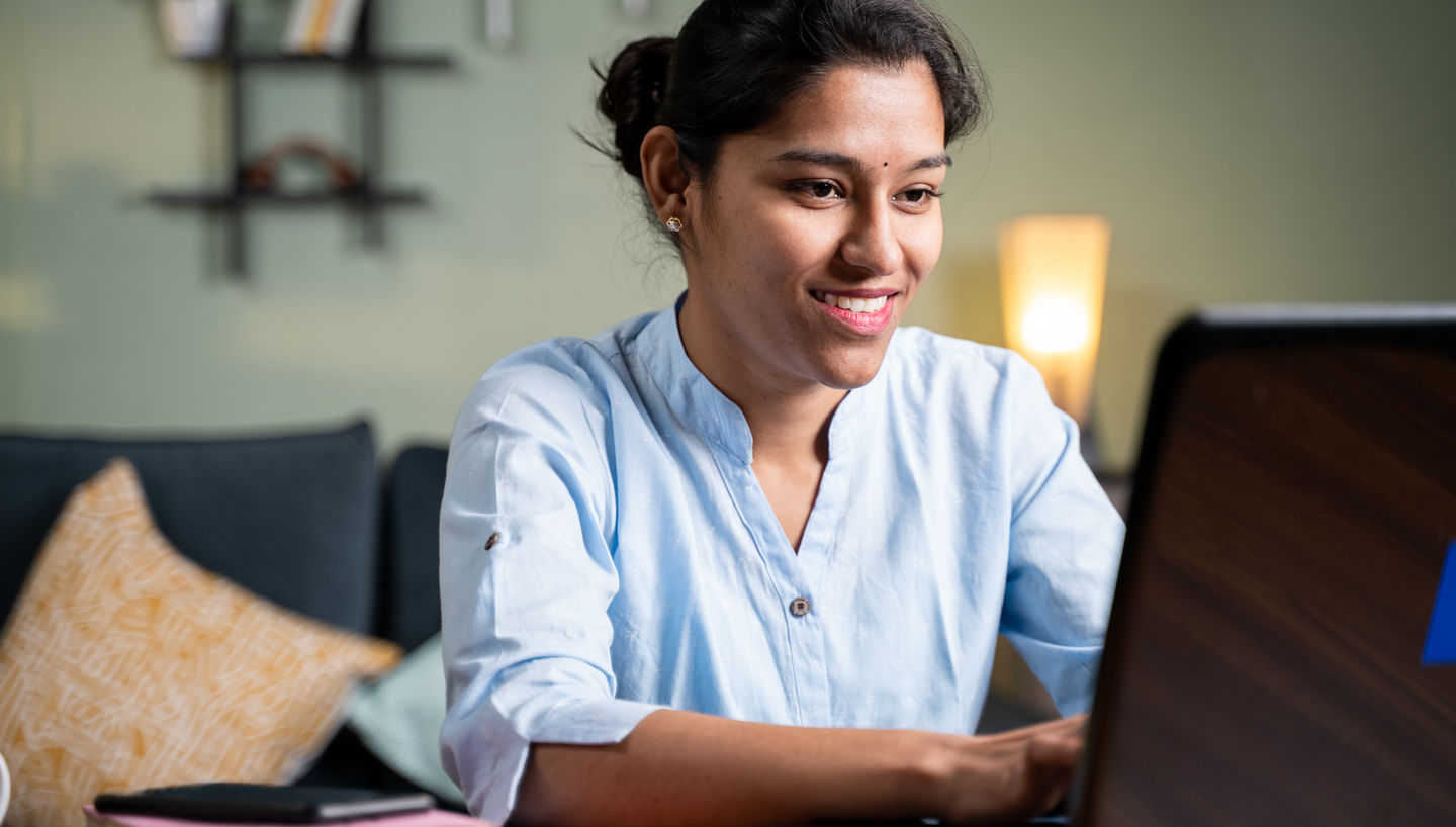 Jetzt bewerben fürs Sommersemester 2022 an der HWR Berlin. Foto: © lakshmiprasad S/iStock/Getty Images Plus Studierende bereitet am Laptop ihre Bewerbung vor und lächelt dabei. Foto: © lakshmiprasad S/iStock/Getty Images Plus