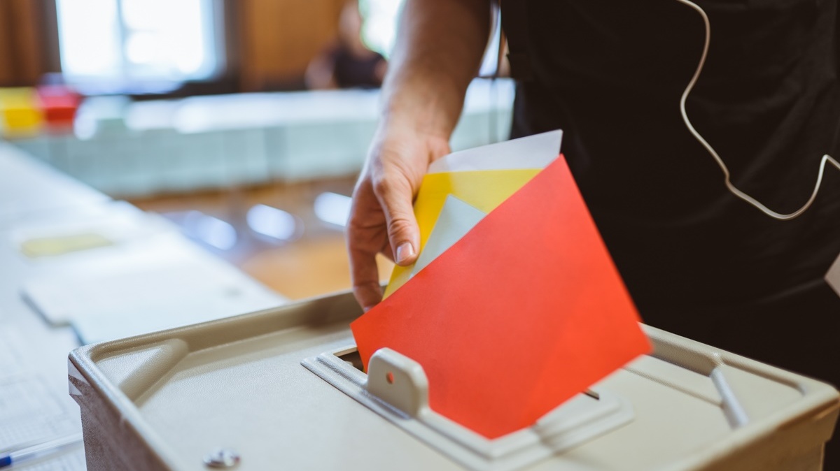 Mitglied wirft bei der Wahl des Akademischen Senats der HWR Berlin einen roten mehrere Stimmzettel in die Wahlurne. Foto: Oana Popa-Costea