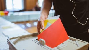 Mitglied wirft bei der Wahl des Akademischen Senats der HWR Berlin einen roten mehrere Stimmzettel in die Wahlurne. Foto: Oana Popa-Costea