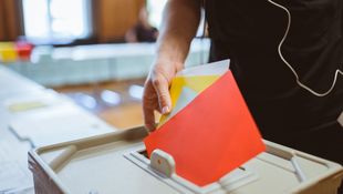 A member of the Academic Senate of the HWR Berlin throws several voting slips into the polling box during the election. Photo: Oana Popa-Costea