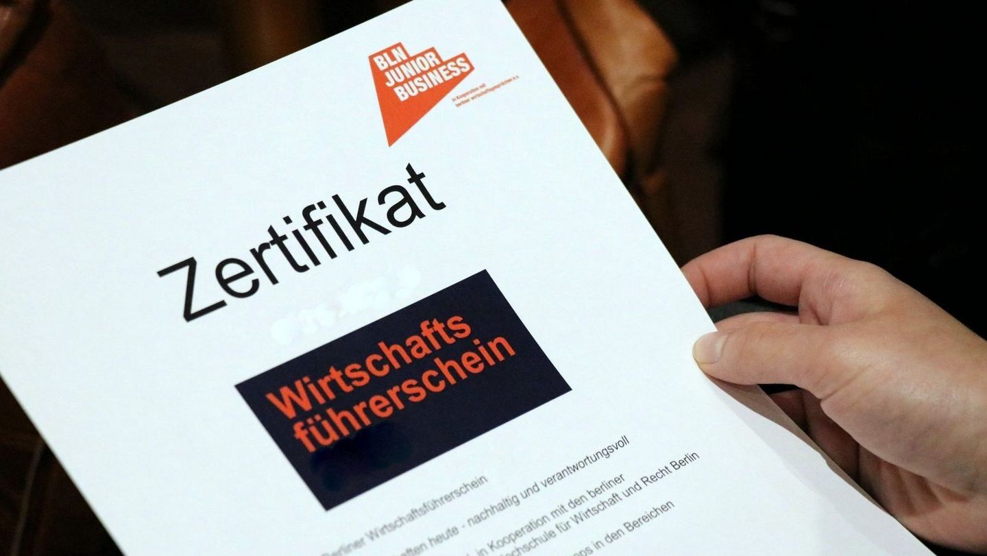 Person hat Zertifikat "Wirtschaftsführerschein" in der Hand