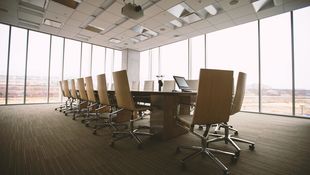 Großer Konferenztisch vor einer Panorama-Glasfront.