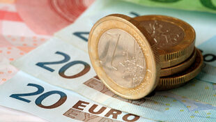 Mehrere Euro-Münzen liegen auf mehreren 20-Euro-Scheinen