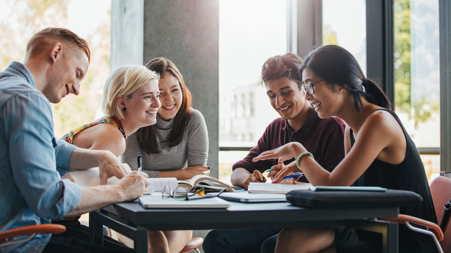 Arbeitsgruppe: Fünf Studierende sitzen am Tisch zusammen. Foto: Getty Images