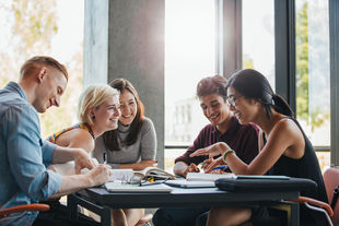 Studium Generale an der HWR Berlin: Eine vielfältige Gruppe von Studierenden sitzt am Tisch und arbeitet an einem Projekt. Foto: Getty Images