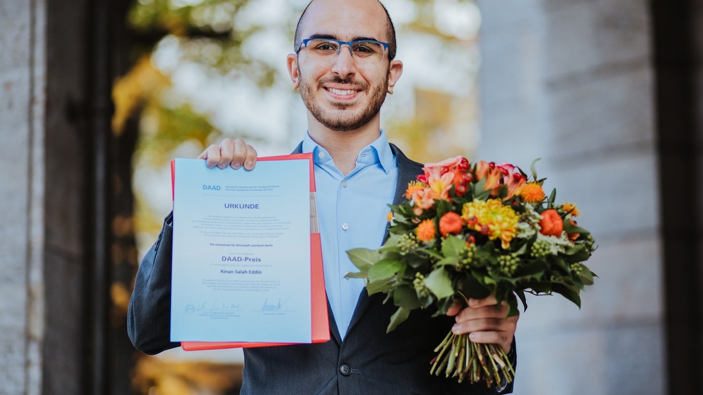 DAAD-Preisträger 2020: Kinan Salah Eddin mit Urkunde und Blumenstrauß. Foto: Oana Popa-Costea