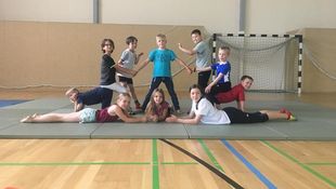 In der Turnhalle der Hochschule für Technik und Wirtschaft Berlin trainierten die Ferienkinder mit den Trainerinnen und Trainern des Zirkus Füdilu, wie man eine Menschenpyramide bildet. Foto: Carlo Just Akrobatik trainieren: Zehn Ferienkinder von Angehörigen der HWR Berlin bilden auf einer Turnmatte eine geometrische Menschenpyramide. Foto: Carlo Just