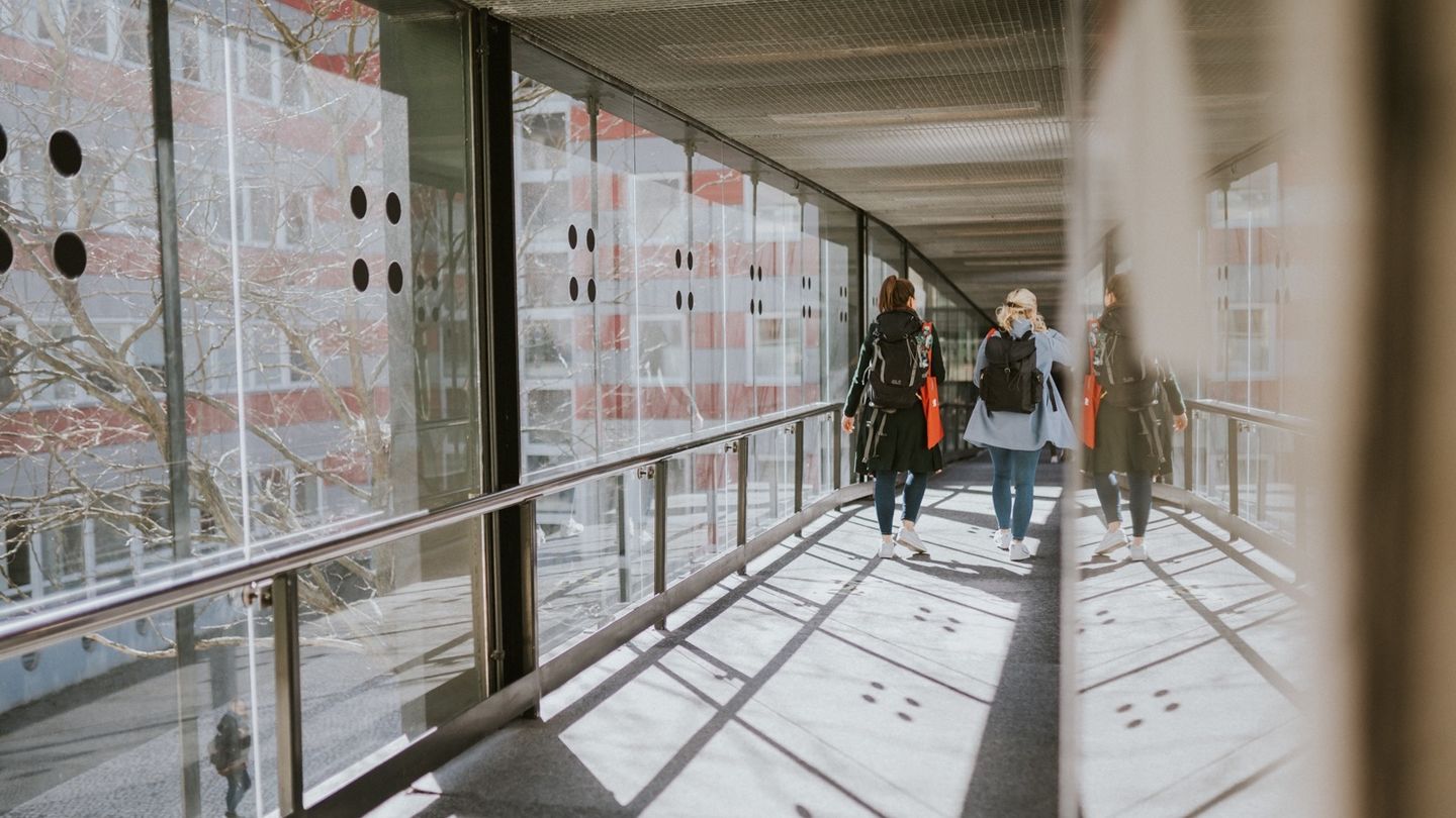 Zwei Studentinnen in einen verglasten Übergang.