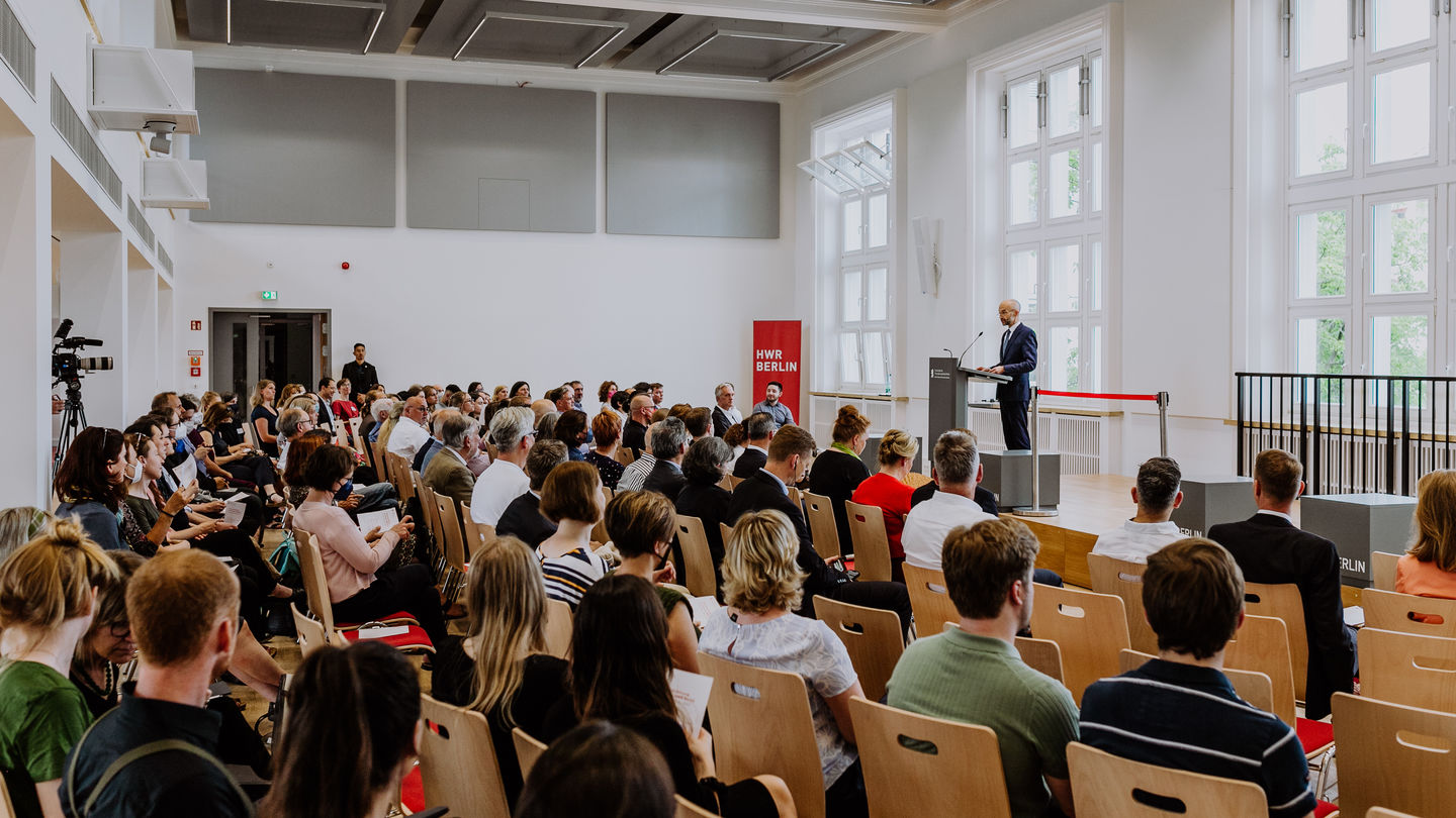 Hochschulpräsident Prof. Dr. Andreas Zaby eröffnet vor vollbesetzten Reihen die neue Aula am Campus Schöneberg der HWR Berlin. Foto: Lukas Schramm