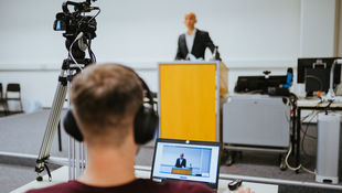 Berlin International Week an der HWR Berlin: Studierender am Laptop verfolgt mit Kopfhörern die Eröffnungsrede von Prof. Dr. Andreas Zaby, Hochschulpräsident der HWR Berlin. Foto: Oana Popa-Costea