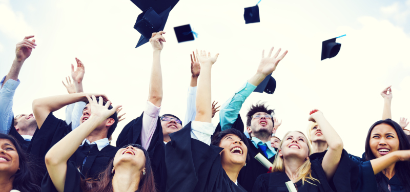 Absolventinnen und Absolventen der Hochschule feiern ihren Abschluss und werfen ihre Hüte in die Luft. Foto: © Rawpixel/iStock/Getty Images Plus